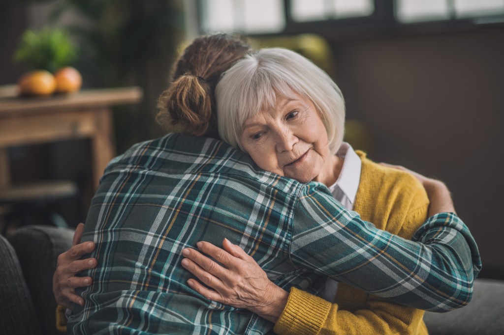 Young man hugs his grandmother.
